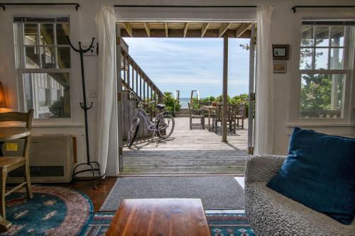 a living room with a door leading to a porch at Waterfront with Private Beach Stunning Views in Provincetown