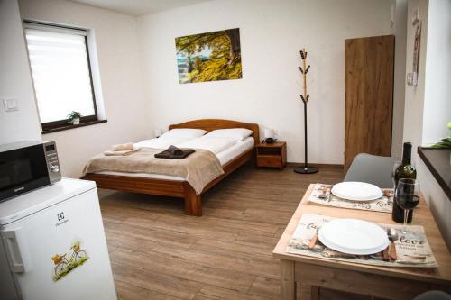 a bedroom with a bed and a table with plates on it at Öreg Fűz Apartman in Mosonmagyaróvár