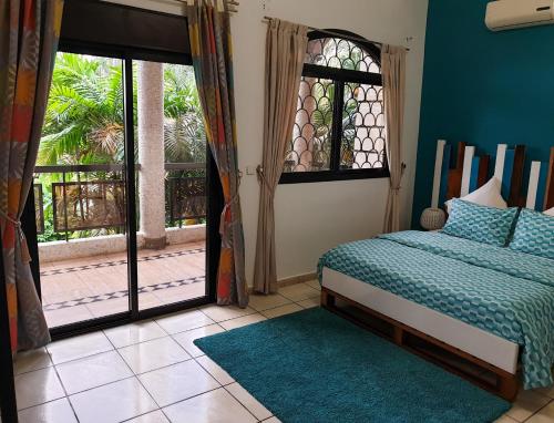a bedroom with a bed and a large window at Villa Mia in Abidjan