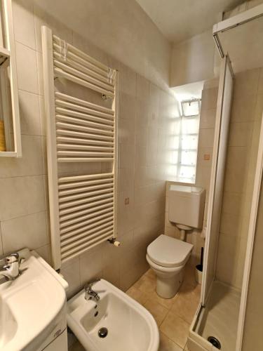 a white bathroom with a toilet and a sink at Casa dello sciatore in Limone Piemonte