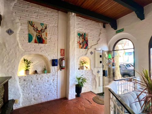 a room with a bed and paintings on the wall at Hotel Los Pinos in Colonia del Sacramento