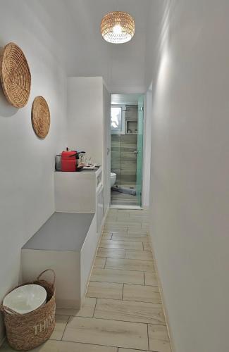 a white bathroom with a sink and a toilet at Tinos Heritage Agora in Tinos