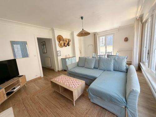 a living room with a blue couch and a tv at GJ Holiday Escapes - Le plage de Notre-Dame - Appartement au coeur de la vieille ville in Boulogne-sur-Mer