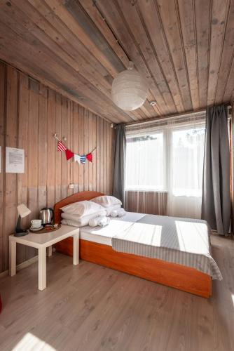 a bedroom with a large bed and a table at Poilsio namai El Nido in Nida