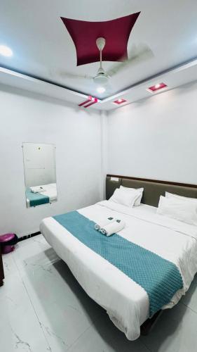 a bedroom with a large bed with a ceiling at Hotel shree lodging in Jogeshwāri