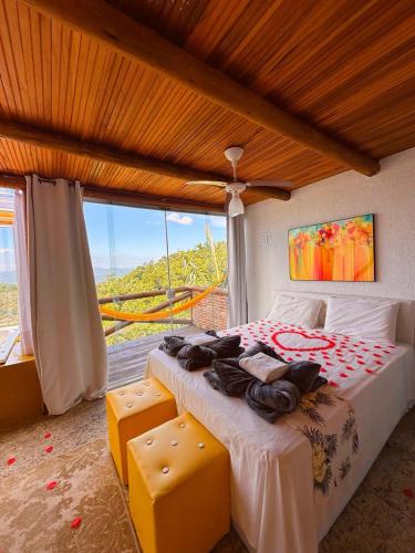 a bedroom with a large bed and a large window at Sítio Emanoel Bangalôs in Domingos Martins
