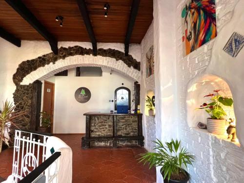 an entry to a house with an archway and plants at Hotel Los Pinos in Colonia del Sacramento