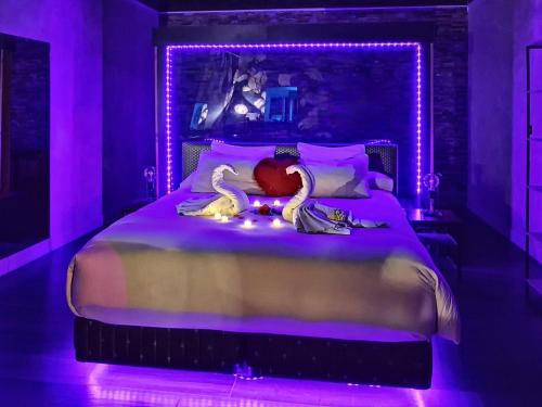 a bedroom with a large bed with purple lighting at Suite avec Jacuzzi - Clim - Terrasse - Wi-Fi in Agde