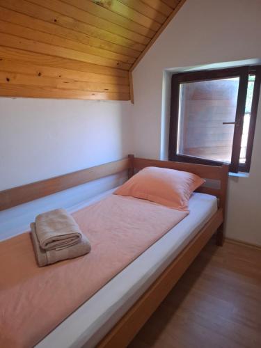 a bed in a small room with a window at Holiday house Šadrvan Sarajevo in Hadžići