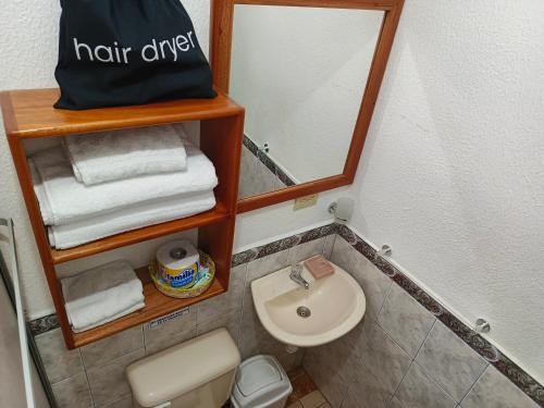 a small bathroom with a sink and a mirror at Teresita's House - Suites con cocina privada in Puerto Baquerizo Moreno