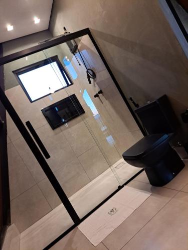a bathroom with a glass shower and a toilet at Paradise In Coffee in Socorro