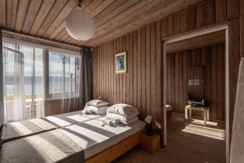 a bedroom with a bed and a large window at Poilsio namai El Nido in Nida