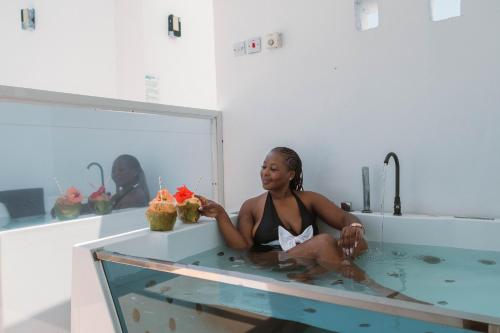 a woman sitting in a bath tub with two cupcakes at ZAN Tropical Beach Adults Only in Dimbuni