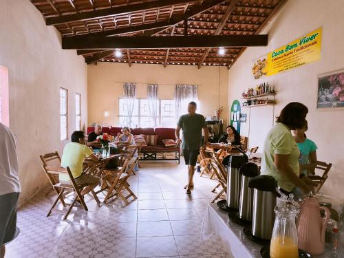 a group of people sitting at tables in a restaurant at Bom Viver Pousada ltda in Viçosa do Ceará