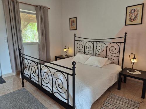 a bedroom with a black bed and a window at Casa da Paz-Martinchel in Casal do Rei