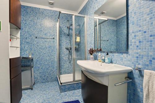 a blue tiled bathroom with a sink and a shower at Casa da Giesta in Roge