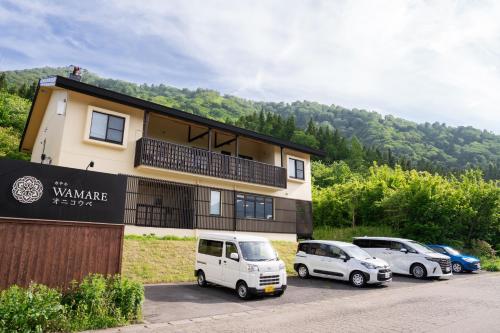 a building with three cars parked in a parking lot at Hotel WAMARE Onikobe in Hara