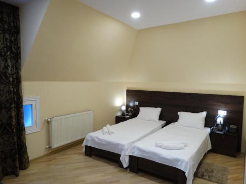 a bedroom with two beds with white sheets at Boutique Hotel Iveria in Tbilisi City
