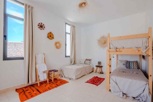 a bedroom with two bunk beds and a window at 3Moon Guesthouse in Aït Yassine