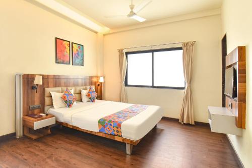 a bedroom with a large bed and a window at FabHotel City Point Executive in Pune