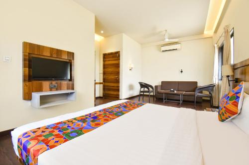 a hotel room with a bed and a flat screen tv at FabHotel City Point Executive in Pune