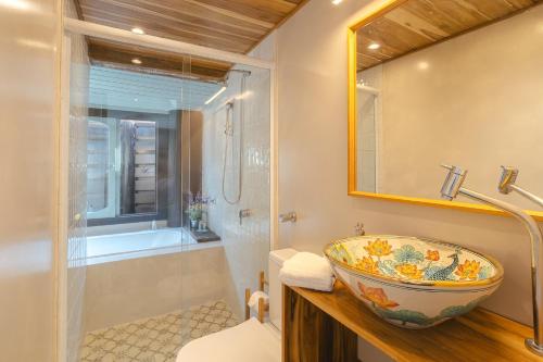 a bathroom with a bowl sink and a shower at Studio Thai na praia in Barra de Ibiraquera