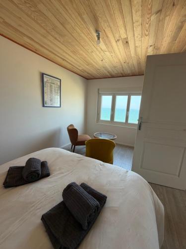 a bedroom with a bed with two towels on it at La Bournonville in Ault