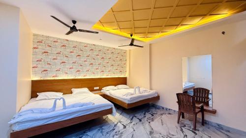 a room with two beds and a mirror at Hotel Gurukripa in Harsola