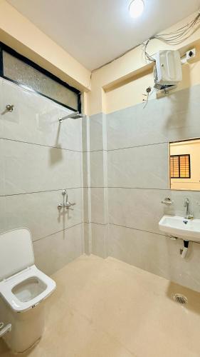 a bathroom with a toilet and a sink at Hotel Gurukripa in Harsola