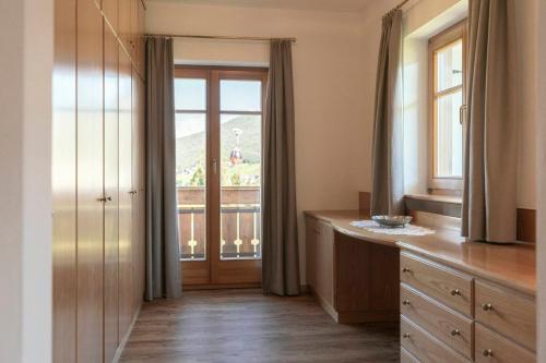 a kitchen with a door and a window with a view at Am Rainell Hof in Ortisei