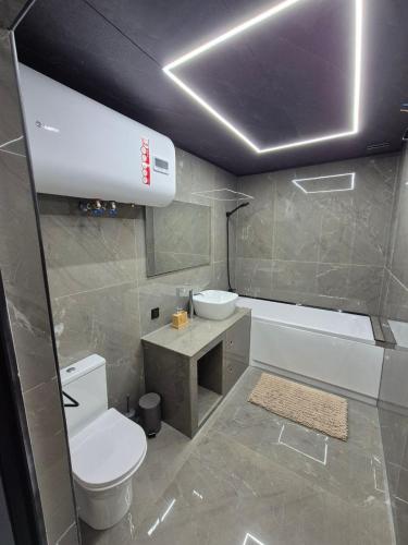 a bathroom with a toilet and a tub and a sink at Sunpark in Vadul lui Vodă