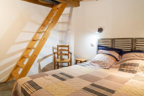a bedroom with a bed and a wooden ladder at Le gîte du comte 2/3 personnes in Saint-Germain-de-Calberte
