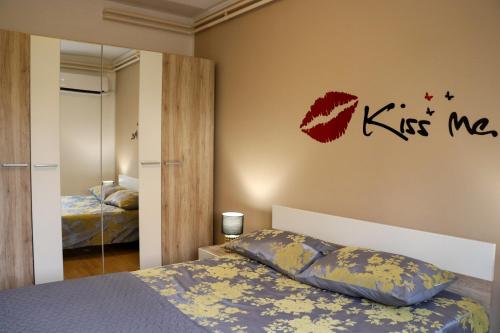 a bedroom with a bed and kiss me sticker on the wall at Paola Apartment in Pula