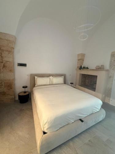 a white bed in a room with a fireplace at Gocce su Pietra in Sannicandro di Bari