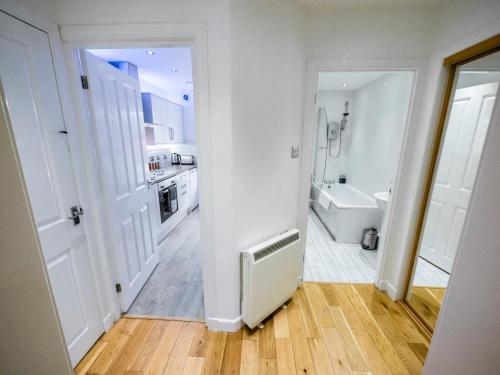 a white bathroom with a tub and a sink at 93 King Street in Broughty Ferry