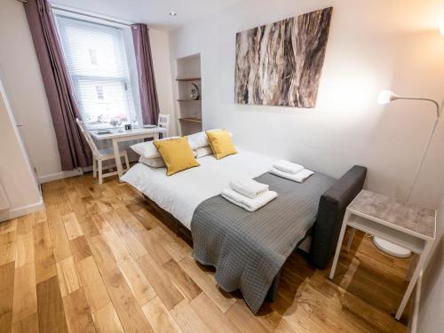 a bedroom with a bed with yellow pillows on it at 93 King Street in Broughty Ferry