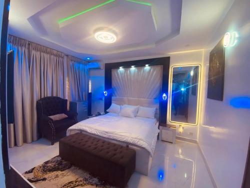 a bedroom with a bed and a chair and lights at Sheylex Apartments in Idogwari