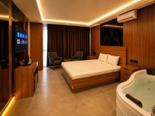 a hotel room with a bed and a bath tub at Palmiye Suite Hotel Bakirkoy City Center in Istanbul