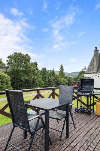 a patio with a table and chairs on a deck at Jock Scott Cottage in Dunkeld