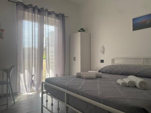 a bedroom with a bed and a large window at Sole & Mare Rooms Briatico in Briatico