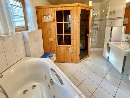 a bathroom with a tub and a toilet and a sink at Sonnenblumenhaus in Nieby