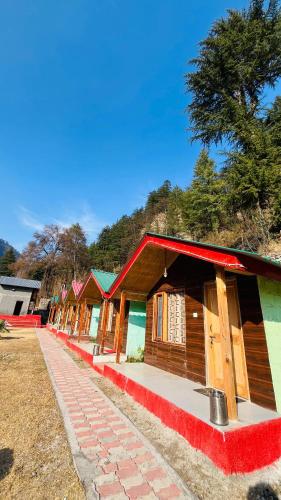 a row of wooden houses in a row at Mahi camping in Jagatsukh