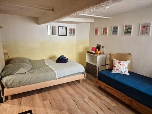a bedroom with two beds and a chair in it at 17m2 Flower studio dans le centre historique Ecusson in Montpellier