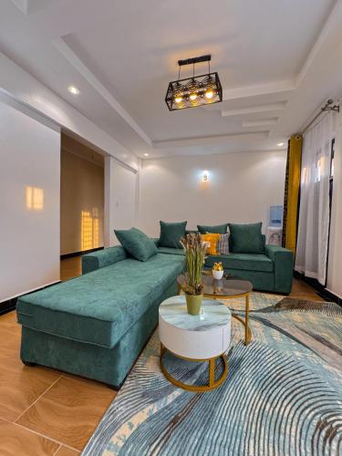 a living room with a green couch and a table at Riverview greenstar homes in Kisii