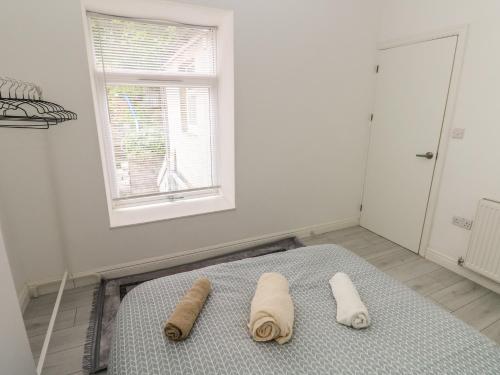 a bedroom with a bed with two towels on it at 5 Gelli Terrace in Caerphilly