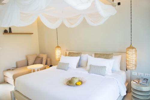 a bedroom with a large white bed with a pineapple on it at The Series Resort Khaoyai in Phayayen
