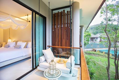 a room with a balcony with a bed and a couch at The Series Resort Khaoyai in Phayayen
