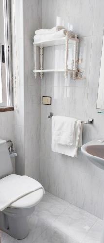 ein weißes Badezimmer mit Toilette und Waschbecken in der Unterkunft Hostal J.B in Malpica