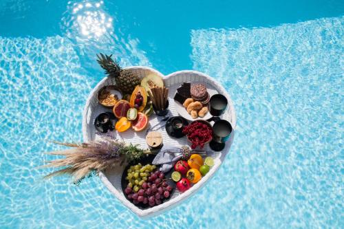 a tray of food in the shape of a heart next to a pool at Nimbus Eden in Agrari