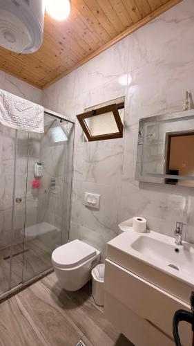 a bathroom with a shower toilet and a sink at - Cemi Rooms - River View & Traditional Restaurant in Tamarë